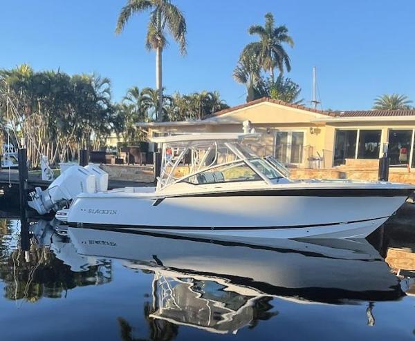 Blackfin 302 DC 2023 Blackfin 302 DC boat docked by a waterfront home with palm trees.