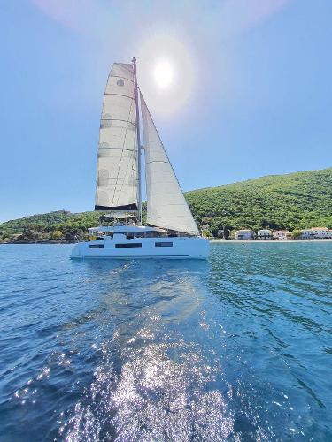Lagoon 50 2019 Lagoon LAGOON 50 sailing on a sunny day with lush green hills in the background.