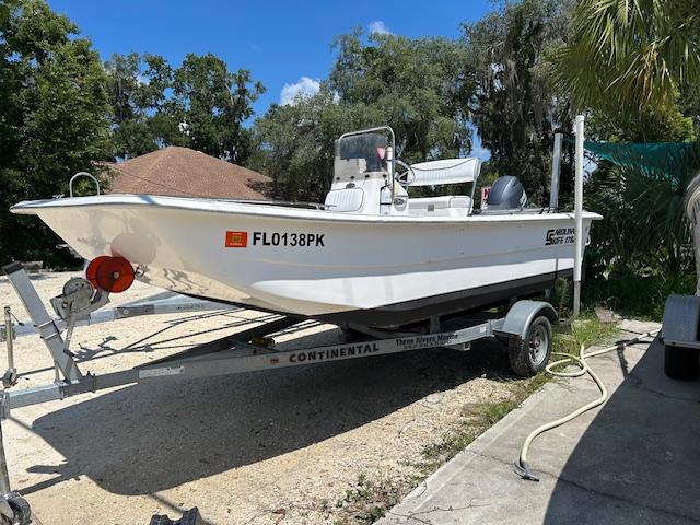 Carolina Skiff 18 DLX 2012 Carolina Skiff 18 DLX boat on trailer, parked outdoors in a sunny setting.