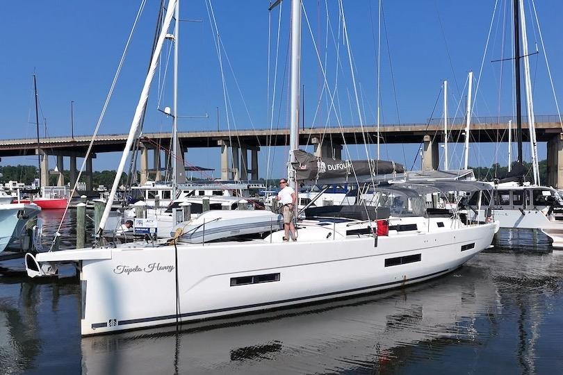 Dufour 530 2022 Dufour 530 sailboat docked at marina, clear blue sky, bridge in background.