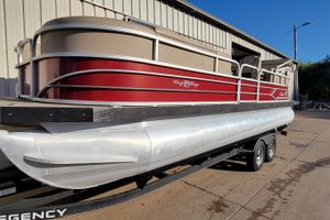 Sun Tracker Party Barge 24 DLX 2019 Sun Tracker Party Barge 24 DLX pontoon boat on trailer, parked outside a building.