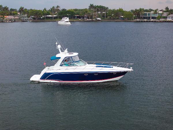Formula 40 PC 2008 Formula 40 Performance Cruiser on calm water, surrounded by lush greenery.