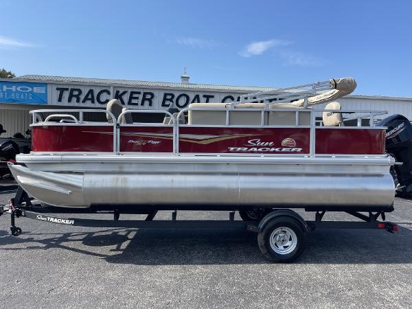 Sun Tracker Bass Buggy 18 DLX 2025 Sun Tracker Bass Buggy 18 DLX pontoon boat on trailer, displayed outdoors.