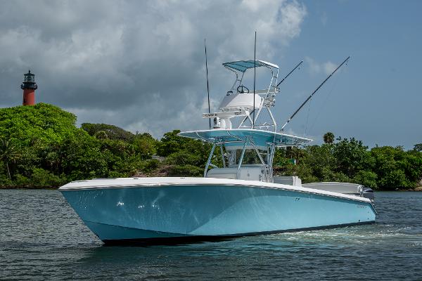 Bahama 41 2015 Bahama 41 boat on water near lush greenery and lighthouse.
