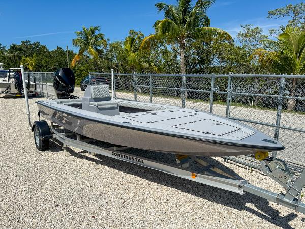 Custom Key Hopper 20 Custom Key Hopper 20 boat on trailer, 2023 model, parked near palm trees and fence.