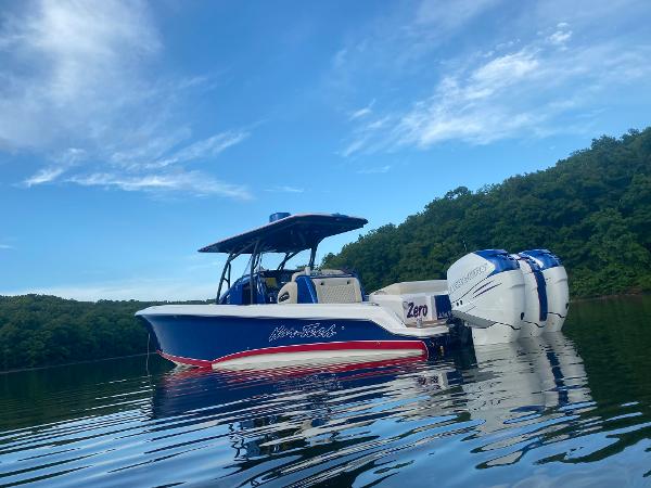 Nor-Tech 340 Sport Center Console 2015 Nor-Tech 340 Sport Center Console boat on calm water, surrounded by lush greenery.