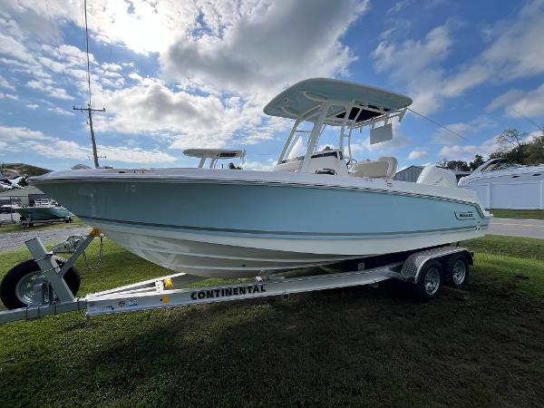 Boston Whaler 230 Outrage 2024 Boston Whaler 230 Outrage boat on trailer under a partly cloudy sky.