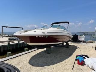 Sea Ray 220 Sundeck 2006 Sea Ray 220 Sundeck boat on dry dock, sunny day, waterfront background.