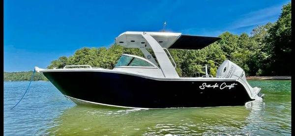 Custom 21 Suzuki Craft 2023 Custom 21 Suzuki Craft boat on a serene lake with lush green trees.