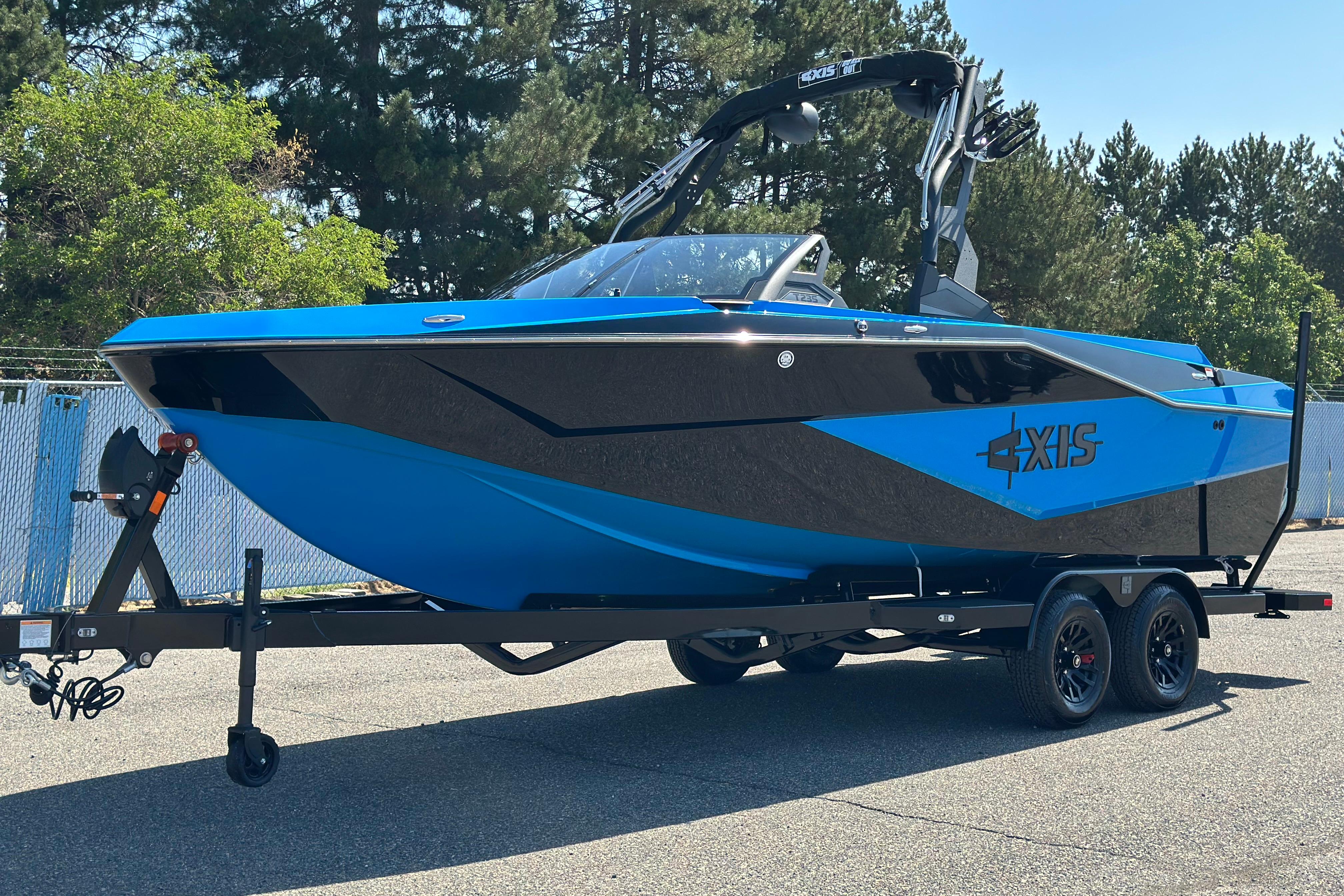 Axis T235 2026 Axis T235 boat in blue and black on a trailer, parked outdoors.