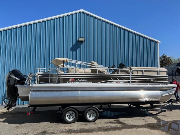 Sun Tracker SportFish™ 22 XP3 2023 Sun Tracker SportFish™ 22 XP3 pontoon boat parked outside blue building.