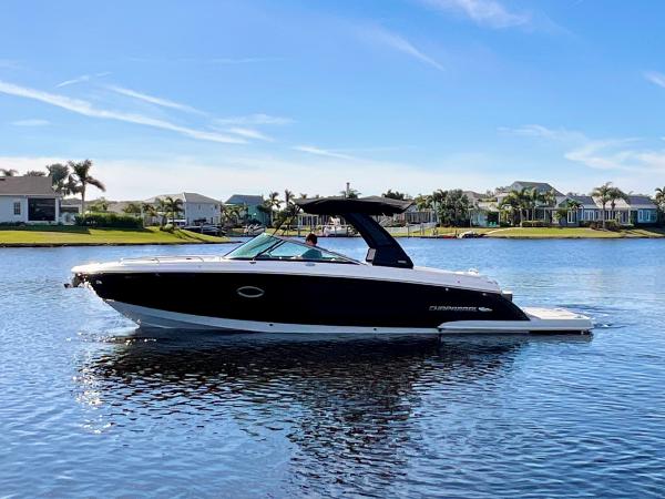Chaparral 307 SSX 2021 Chaparral 307 SSX boat on a sunny lake with houses in the background.