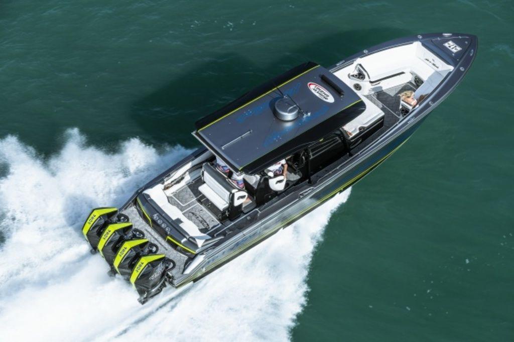 Nor-Tech 390 Sport 2024 Nor-Tech 390 Sport boat cruising on water with triple outboard engines.