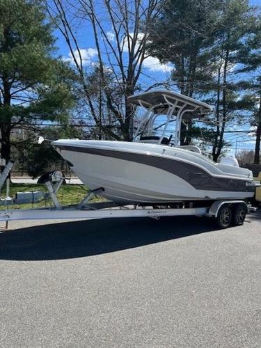 Finseeker 230 2024 Finseeker 230 boat on trailer, parked outdoors with trees in background.