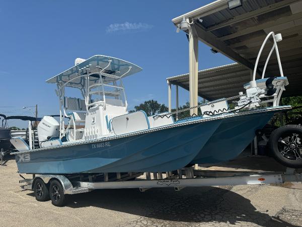 Shallow Sport 25 X3 2025 Shallow Sport 25 X3 boat on trailer, blue hull, parked under a canopy.