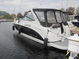 Chaparral Signature 330 2005 Chaparral Signature 330 boat docked in a marina, featuring a sleek black and white design.