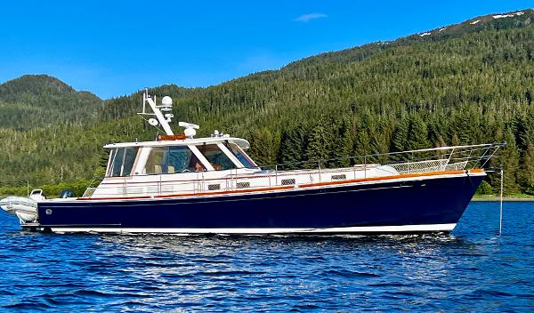 Grand Banks 49 Eastbay HX 2001 Grand Banks 49 Eastbay HX yacht on scenic water with forested hills.