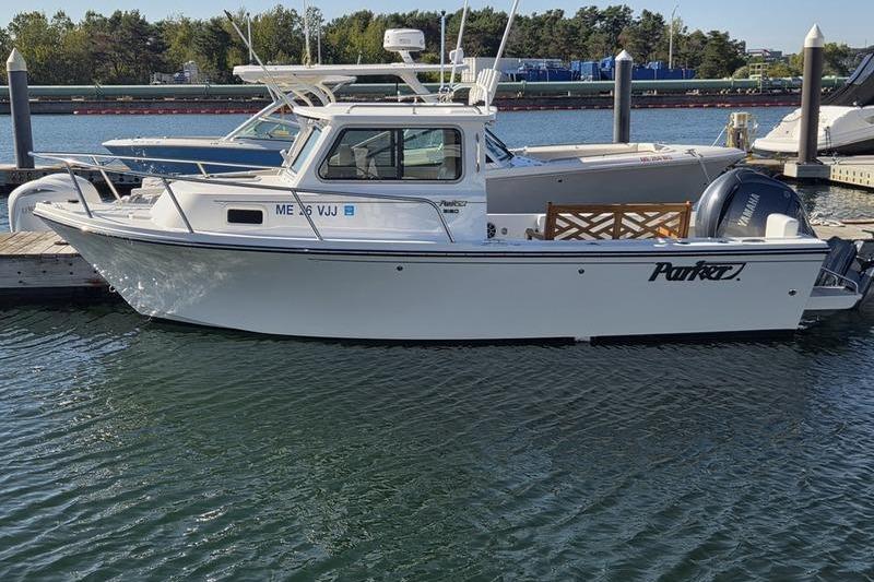 Parker 2120 Sport Cabin 2025 Parker 2120 Sport Cabin boat docked in a marina, side view.