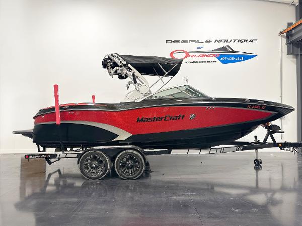 MasterCraft X23 2015 MasterCraft X23 boat in showroom, red and black design, on a trailer.