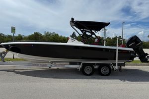 Concept 27' CC 2015 Concept 27' CC boat on trailer, black hull, parked outdoors under cloudy sky.