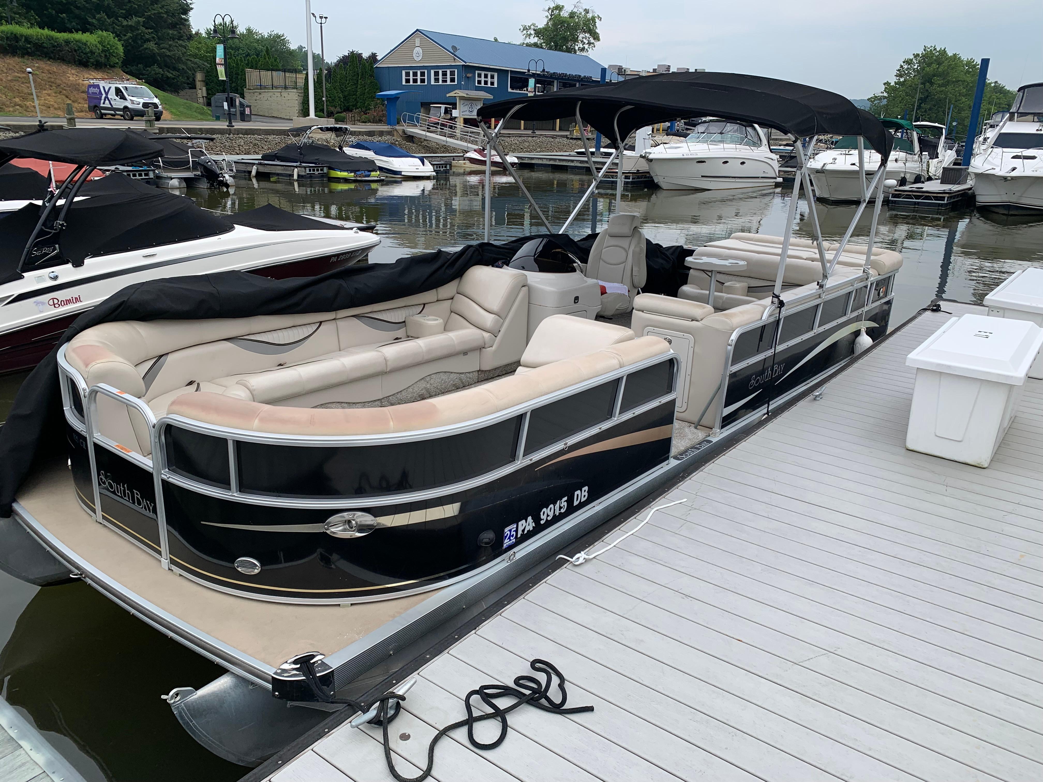 South Bay 825 Cr 2009 South Bay 825 CR pontoon boat docked at marina with covered seating.