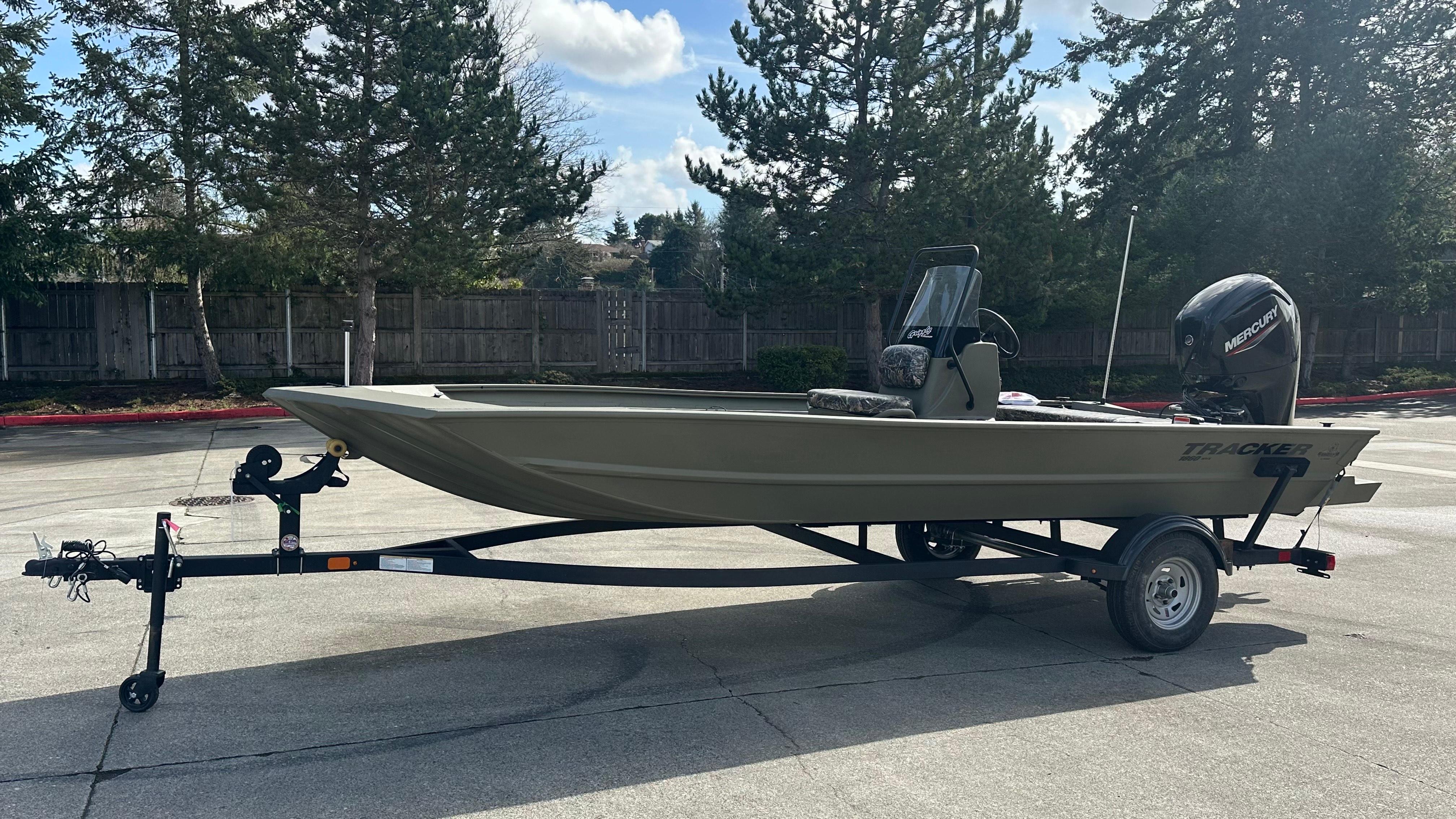 Tracker Grizzly 1860 CC 2025 Tracker Grizzly 1860 CC boat on trailer, parked outdoors.
