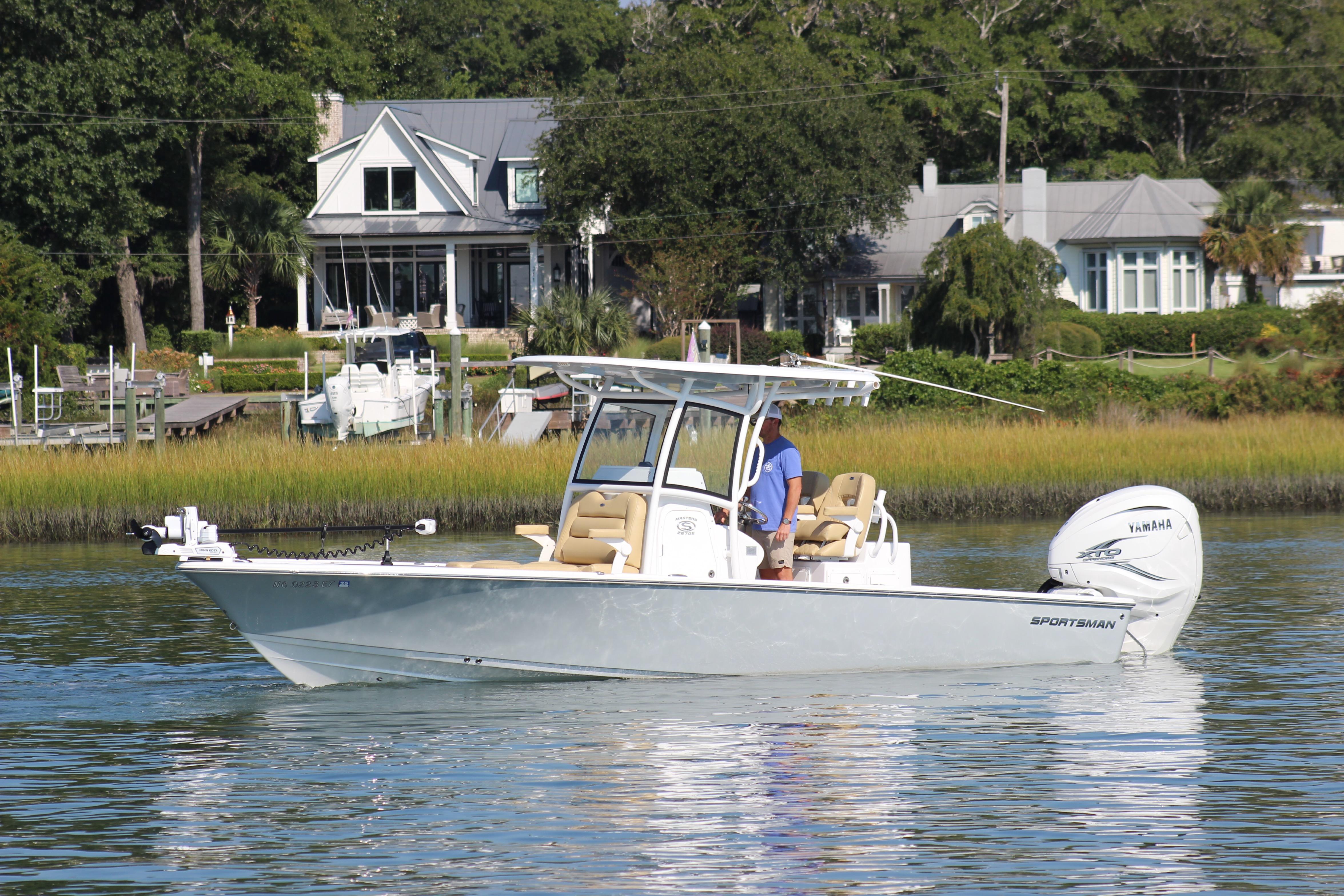 Sportsman Masters 267OE Bay Boat 2021 Sportsman Masters 267OE Bay Boat cruising on a calm river near waterfront homes.