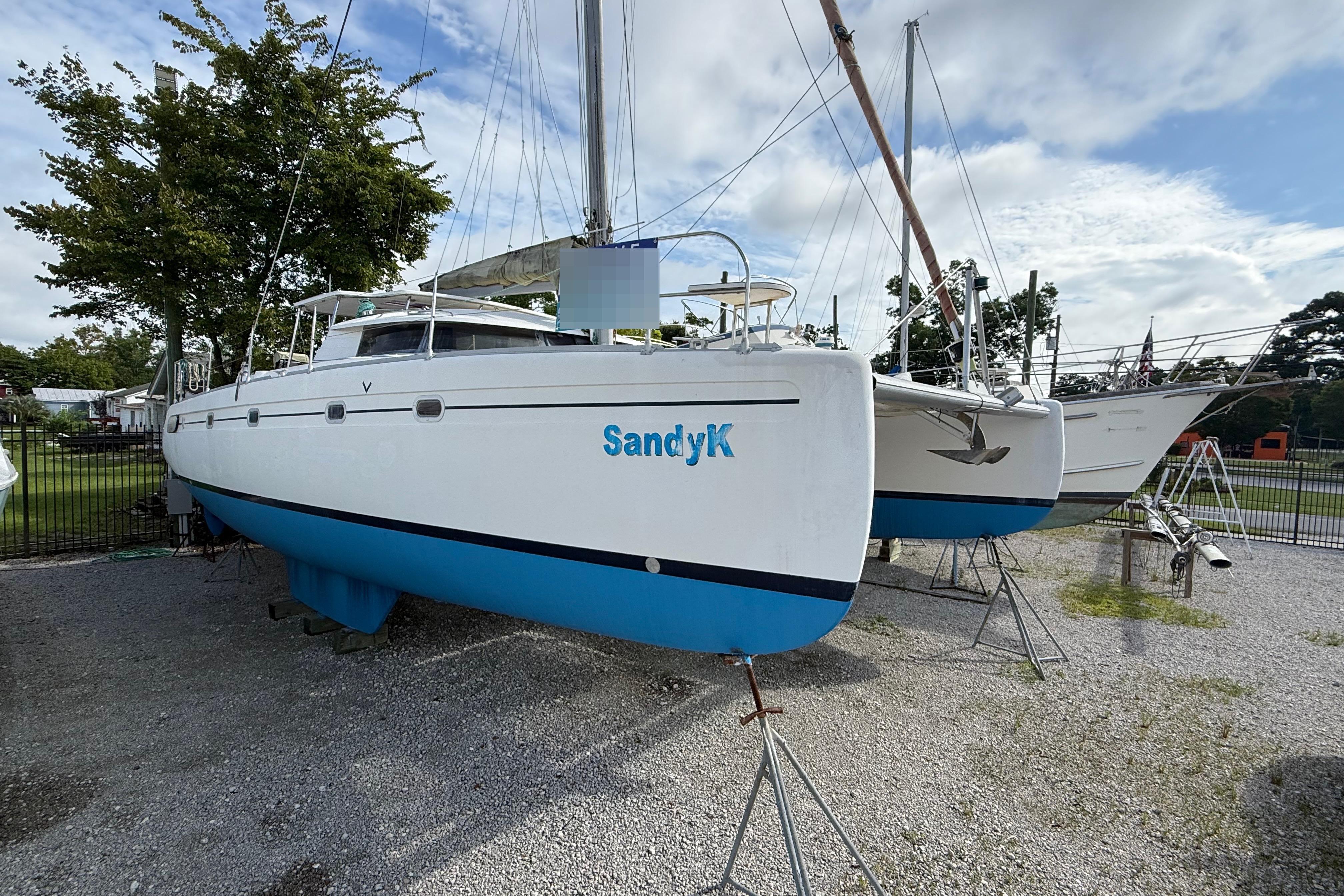 Fountaine Pajot Venezia 42 1996 Fountaine Pajot Venezia 42 catamaran on land, white hull, blue bottom, named "SandyK".