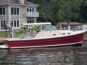 Mainship Pilot 30 Sedan 2001 Mainship Pilot 30 Sedan boat docked near a waterfront house.