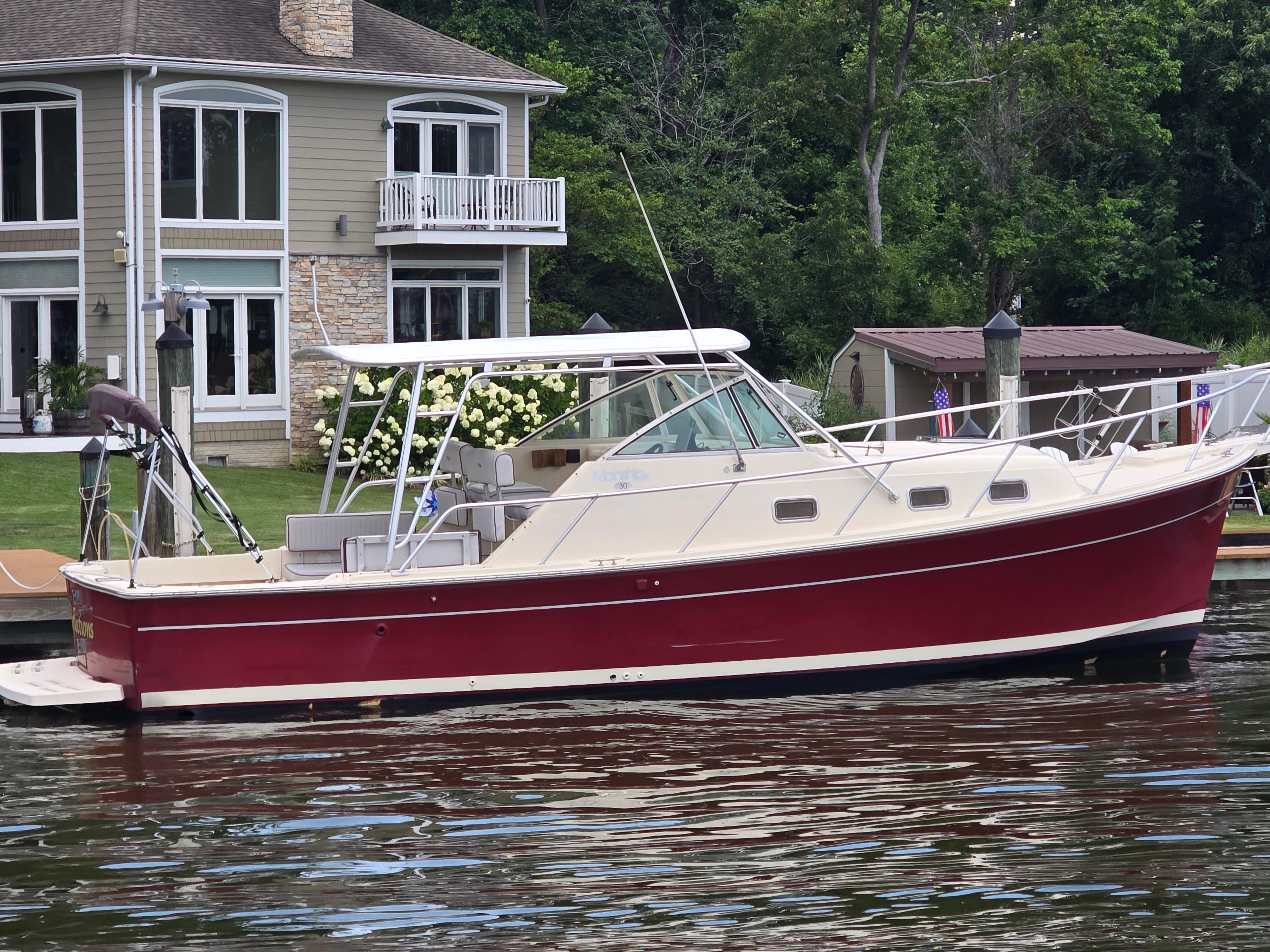 Mainship Pilot 30 Sedan 2001 Mainship Pilot 30 Sedan boat docked near a waterfront house.