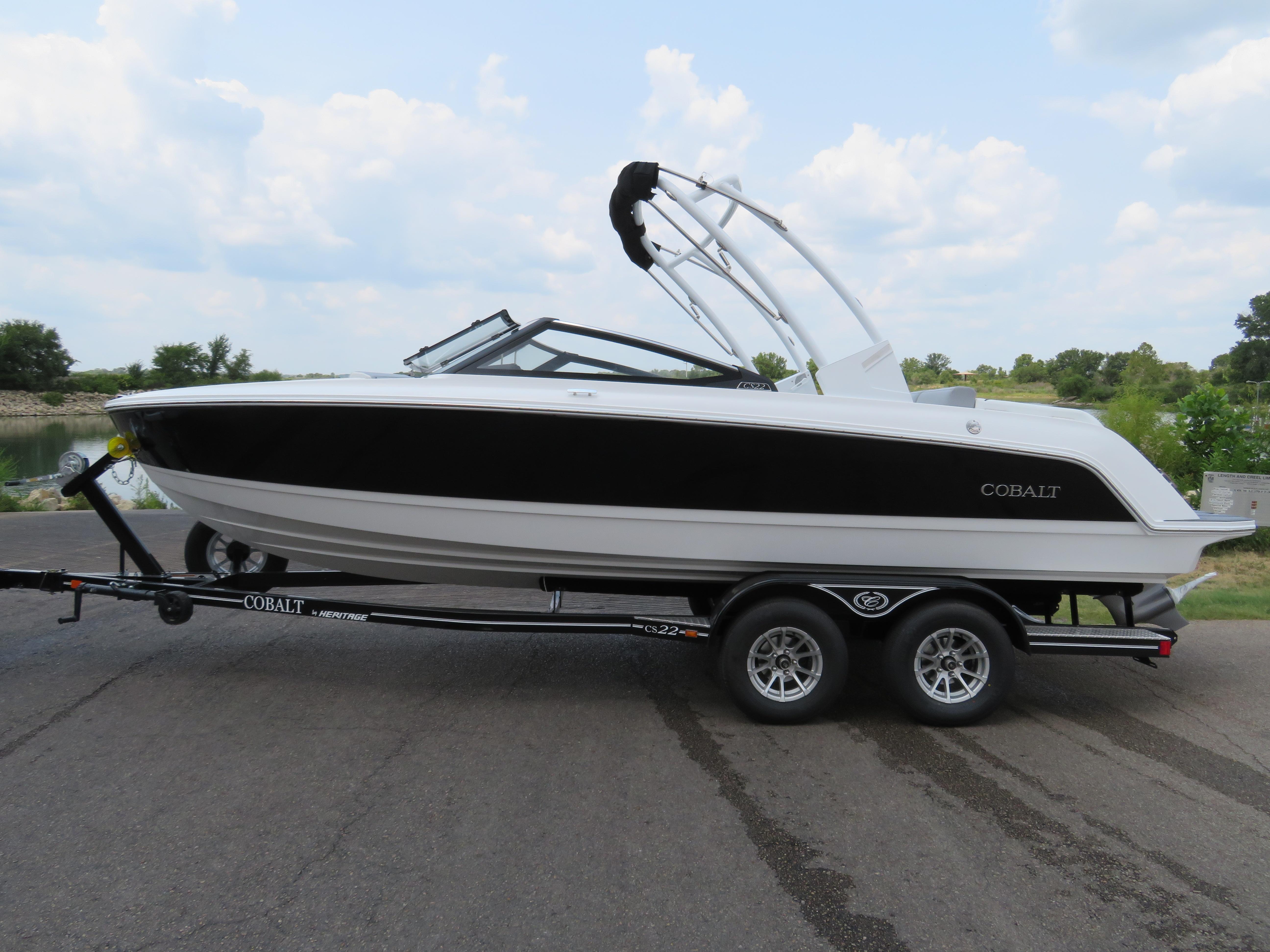 Cobalt CS22 2025 Cobalt CS22 boat on trailer, parked on a road with a scenic background.