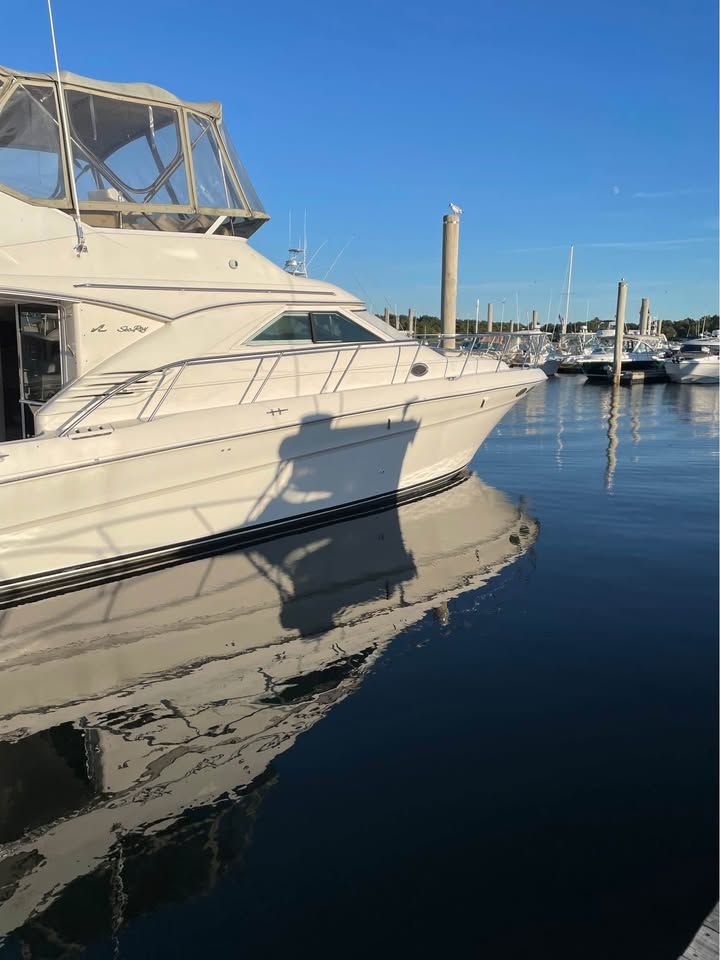 Sea Ray 400 Sedan Bridge 1998 Sea Ray 400 Sedan Bridge yacht docked in a marina, reflecting on calm water.
