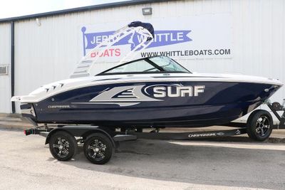 Chaparral 21 Surf 2025 Chaparral 21 Surf boat on trailer, blue and white design, parked outside dealership.