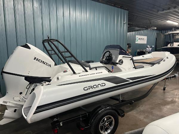 Grand G500HLF 2025 Grand G500HLF boat with Honda engine in a showroom.
