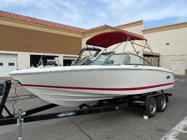 Cobalt 220S 2017 Cobalt 220S boat with red canopy on a trailer in a parking lot.