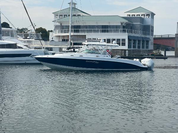 Donzi 38 ZSF 2008 Donzi 38 ZSF boat docked in marina, with waterfront building in background.