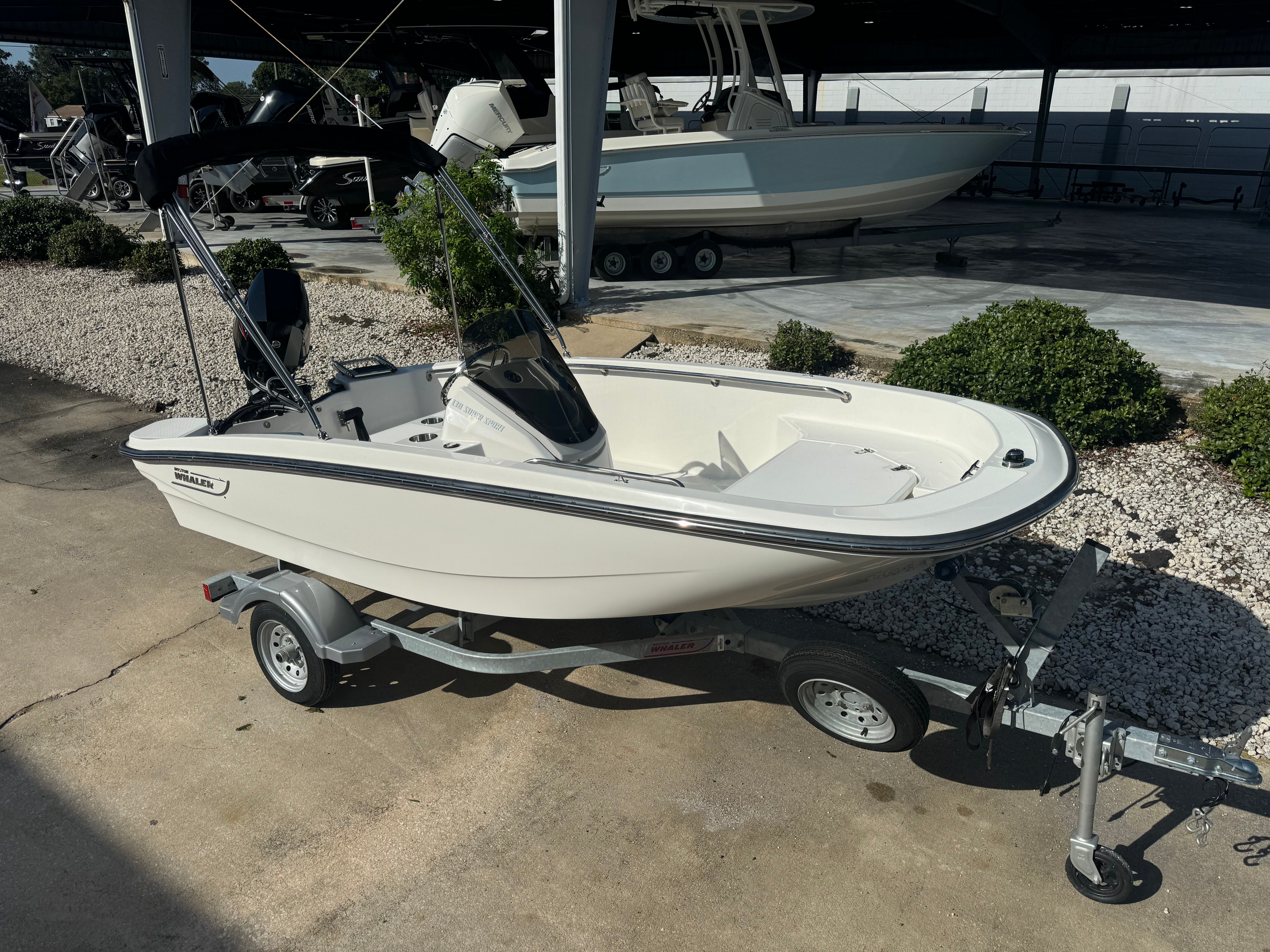 Boston Whaler 130 Super Sport 2024 Boston Whaler 130 Super Sport boat on trailer, parked outdoors.