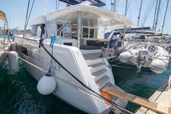 Lagoon 52 F 2018 Lagoon 52 F catamaran docked at marina, featuring spacious deck and modern design.