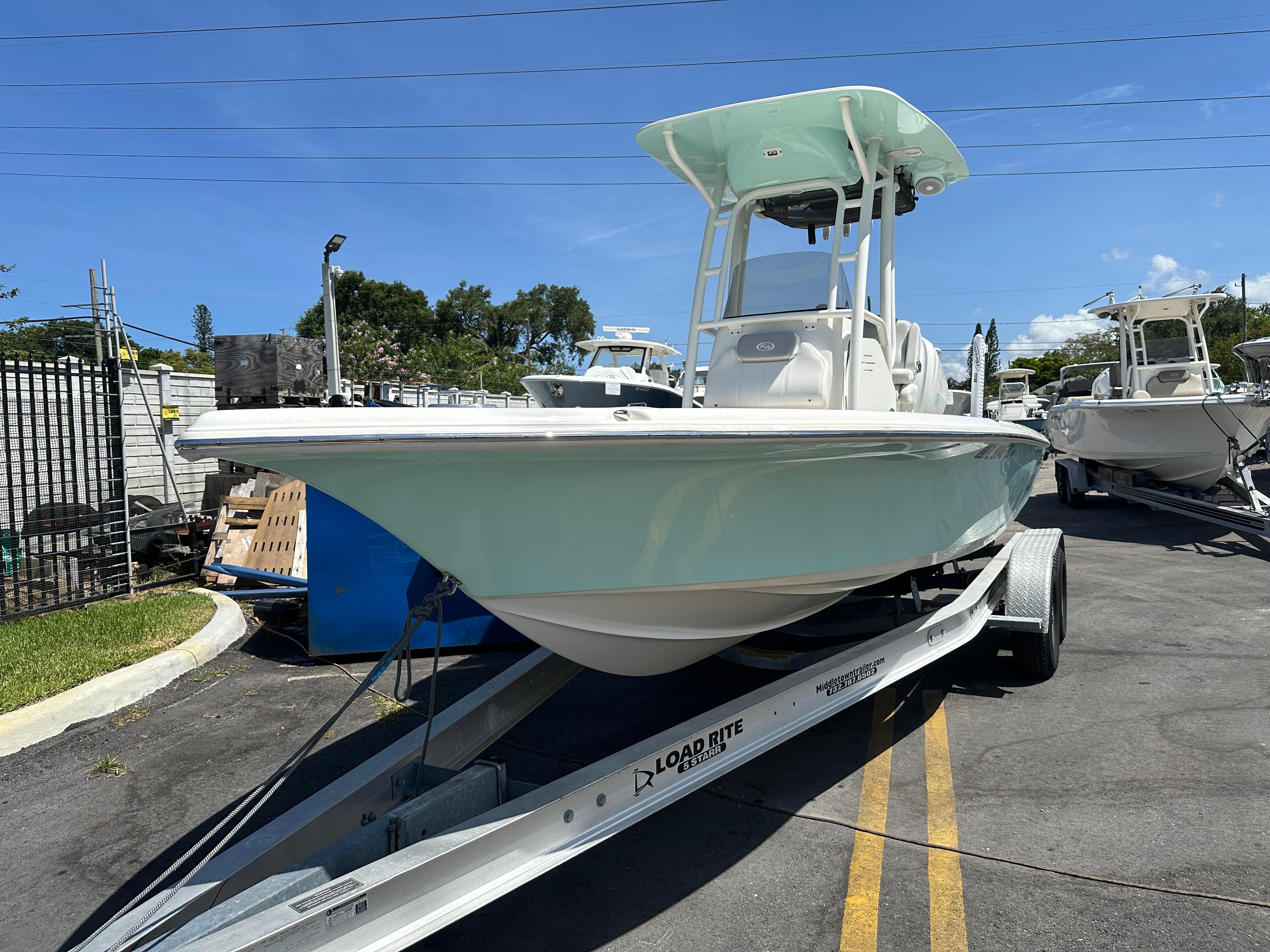 Key West 230 Bay Reef 2024 Key West 230 Bay Reef boat on trailer, displayed outdoors under clear blue sky.