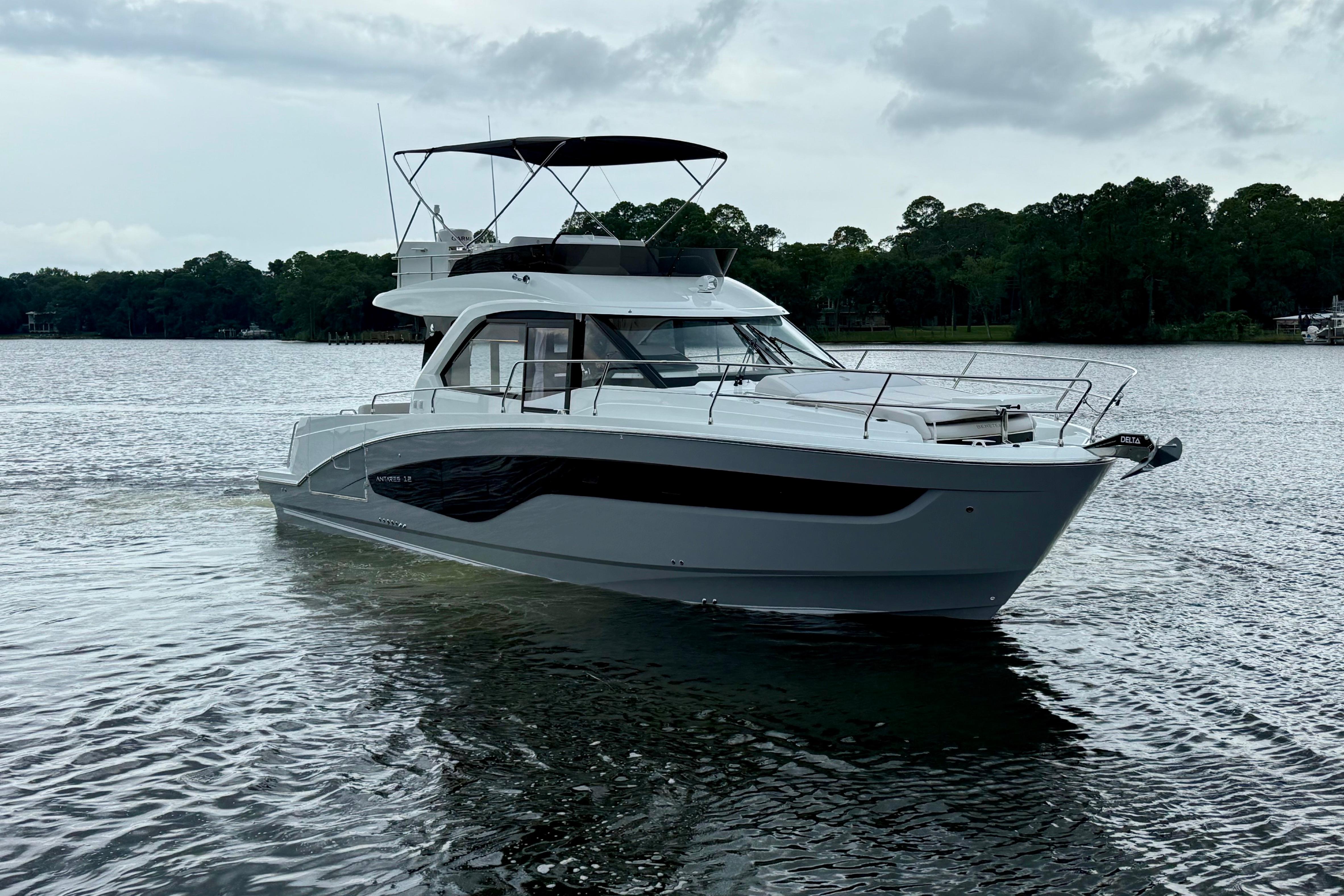 Beneteau Antares 12 2026 Beneteau Antares 12 yacht on a serene lake with lush green background.