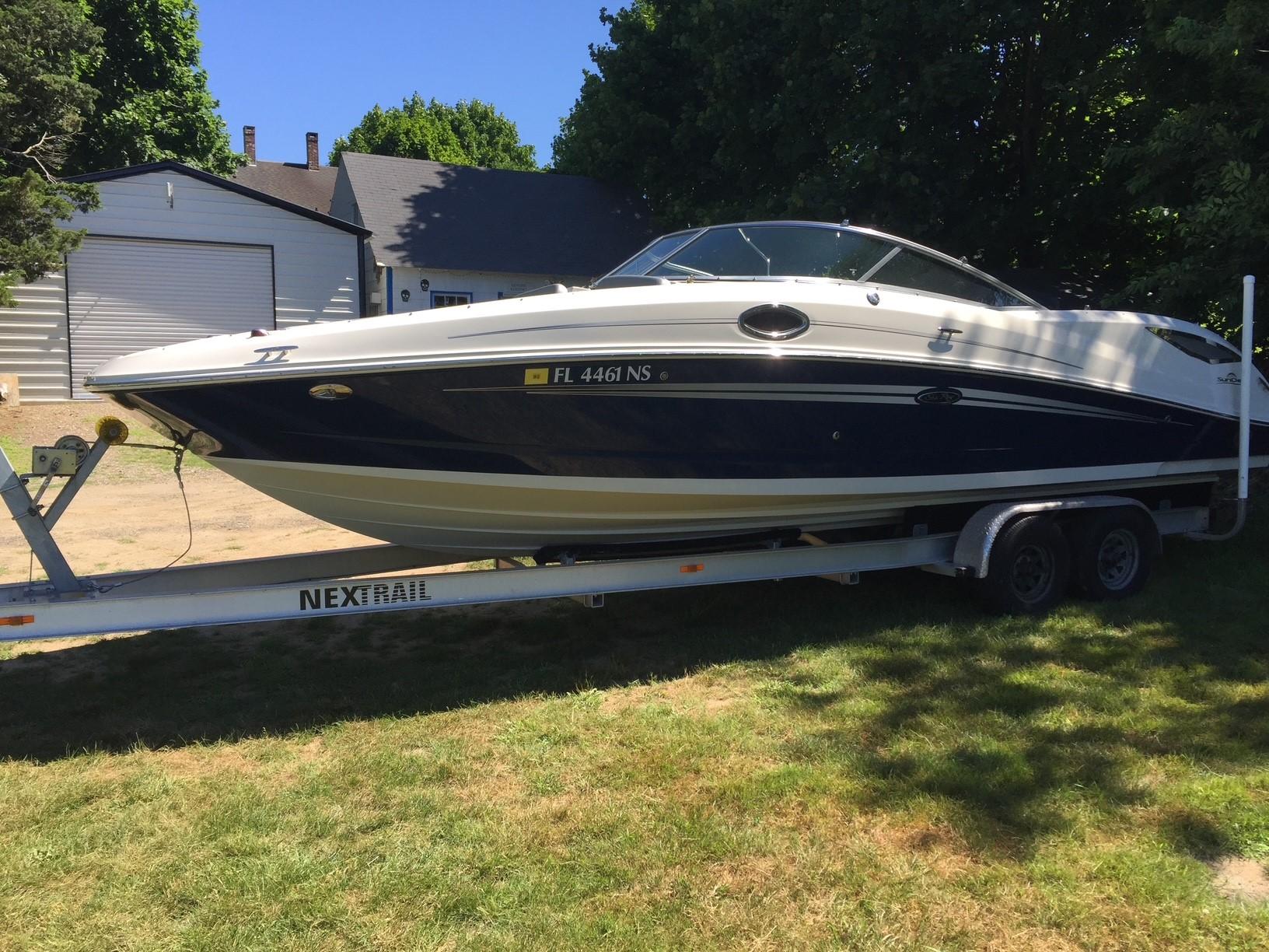 Sea Ray 290 Sundeck 2008 Sea Ray 290 Sundeck boat on trailer, parked on grass near trees.