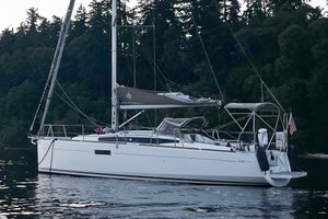 Jeanneau Sun Odyssey 349 2016 Jeanneau Sun Odyssey 349 sailboat anchored near forested shoreline.