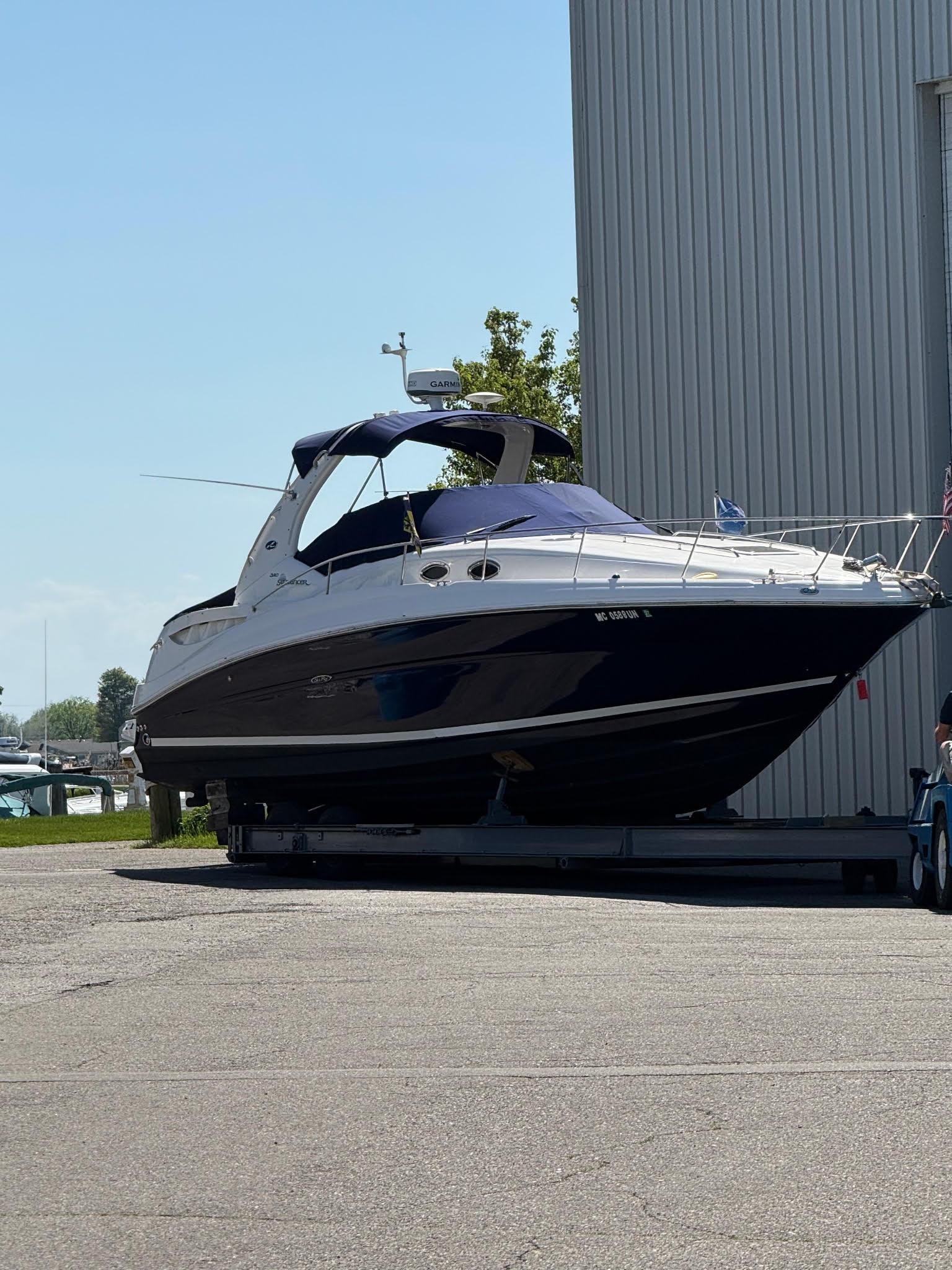 Sea Ray 320 Sundancer 2006 Sea Ray 320 Sundancer boat on trailer near a marina, sunny day.