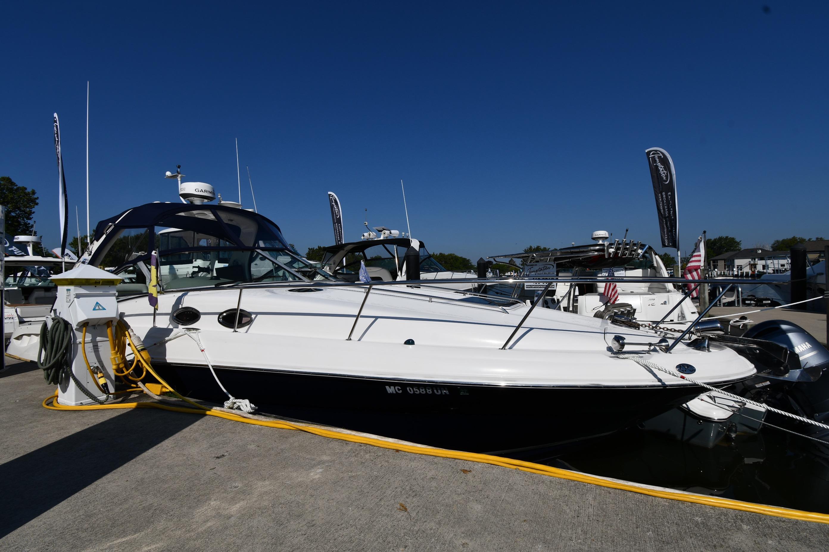 Sea Ray 320 Sundancer 2006 Sea Ray 320 Sundancer docked at marina under clear blue sky.