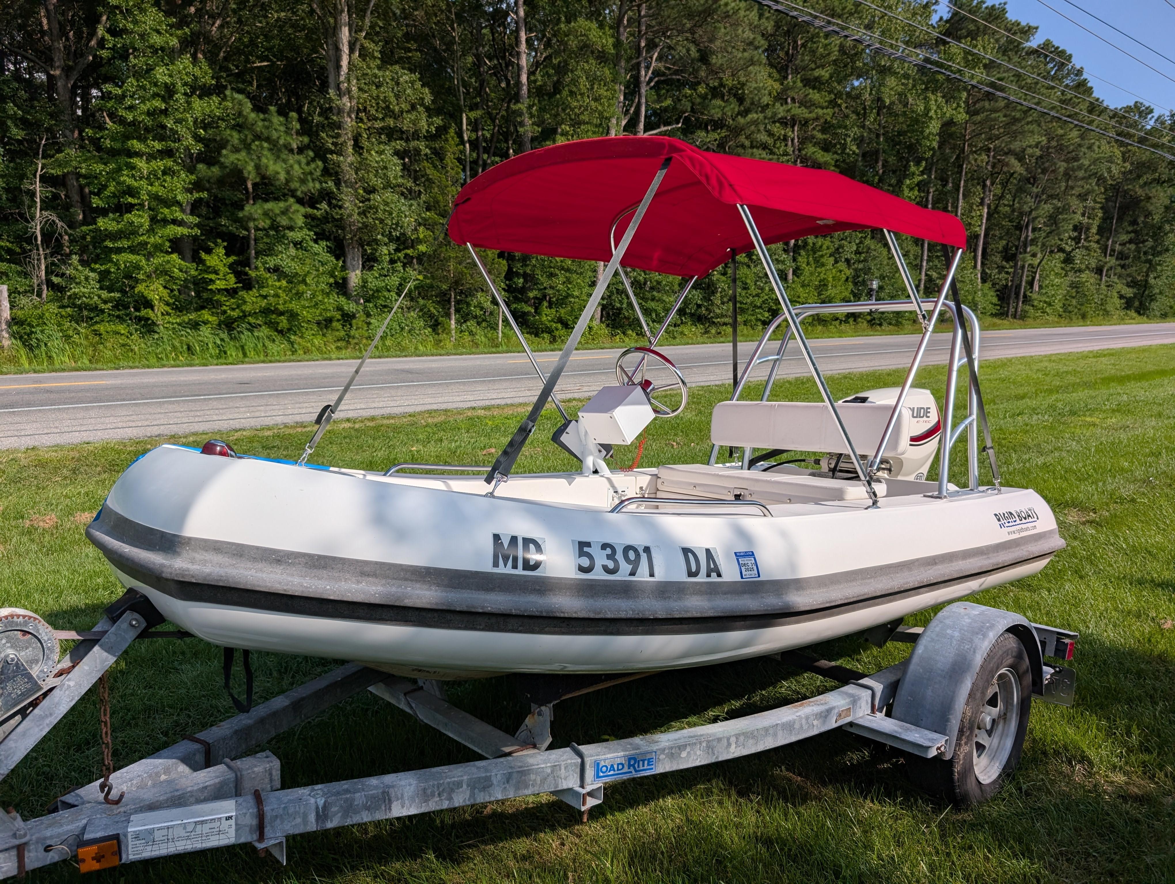 Rigid Boats Sport Tender 2011 Rigid Boats Sport Tender with red canopy on trailer, parked by roadside.