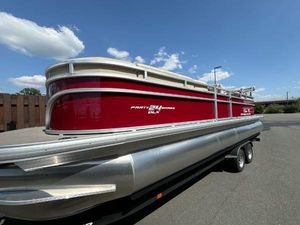 Sun Tracker Party Barge 24 DLX 2025 Sun Tracker Party Barge 24 DLX pontoon boat on trailer, red and silver design.