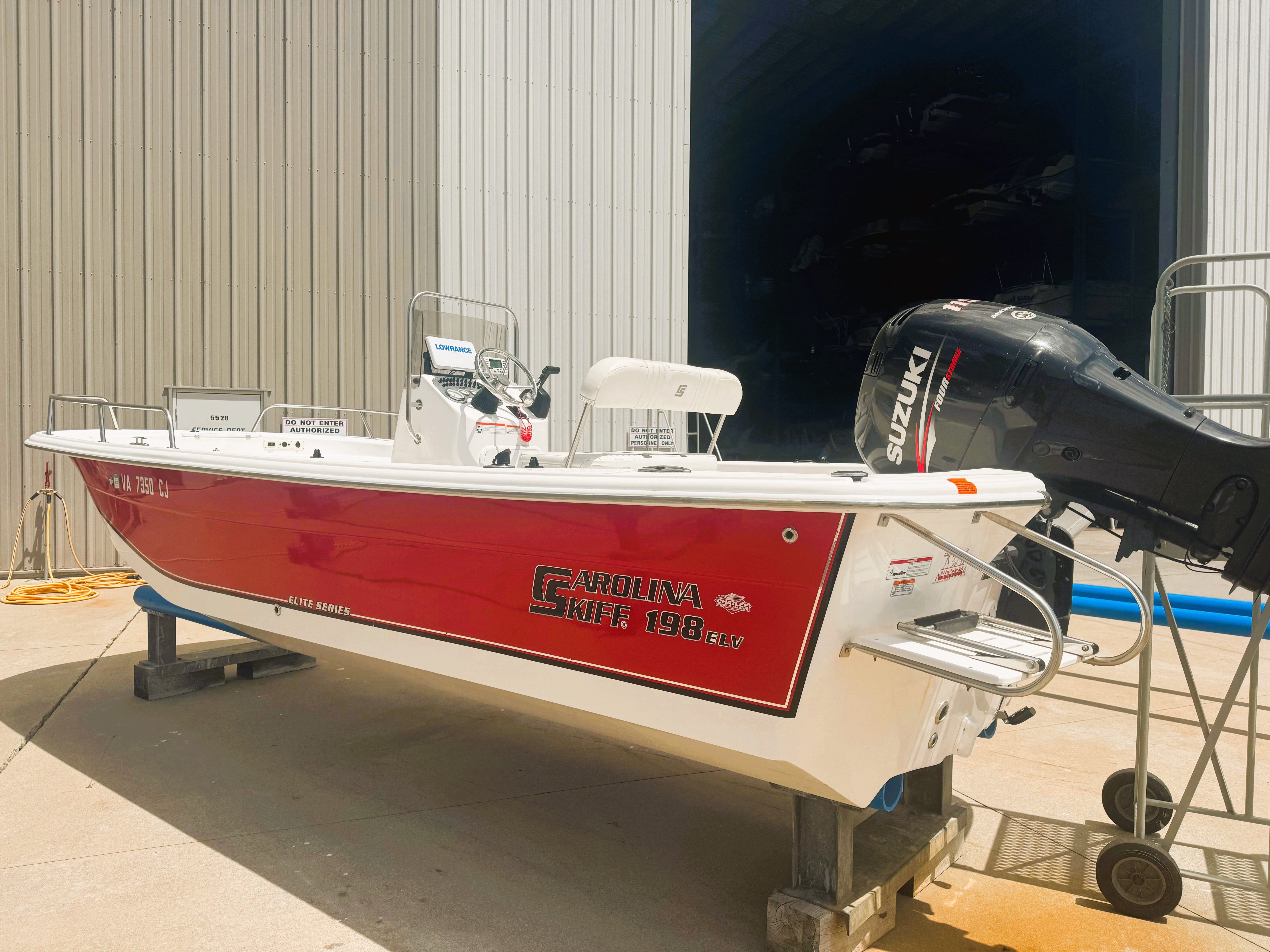 Carolina Skiff Elite Series DLV 198 2010 Carolina Skiff Elite Series DLV 198 boat with Suzuki outboard motor in a garage.