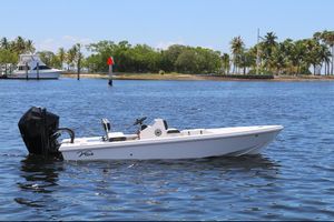 Vtech 18 2024 Vtech 18 boat on calm water with tropical island background.