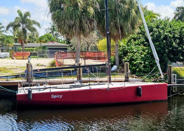 C&C Mega 30 One Design Red C&C Mega 30 One Design sailboat docked by palm trees, 2014 model.