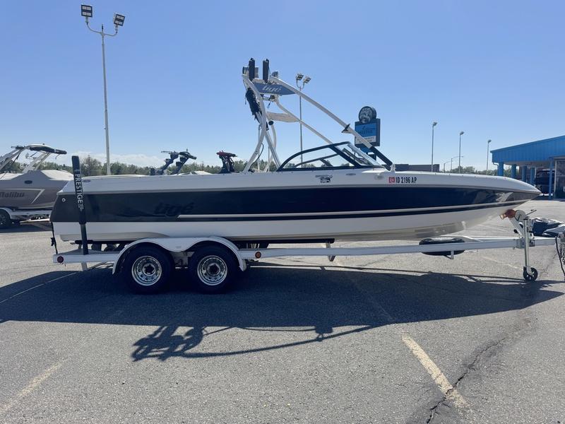 Tigé 2300V Limited 2002 Tigé 2300V Limited boat on trailer in parking lot, sunny day.